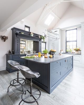 New shaker-style kitchen with deep blue units and silver metal bar stools
