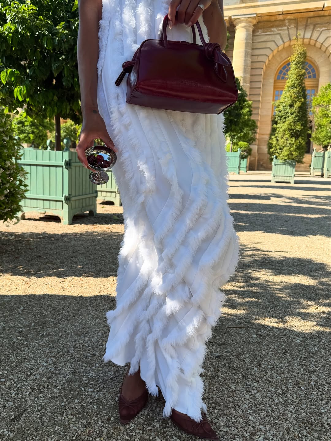 Laura Harrier wearing burgundy shoes