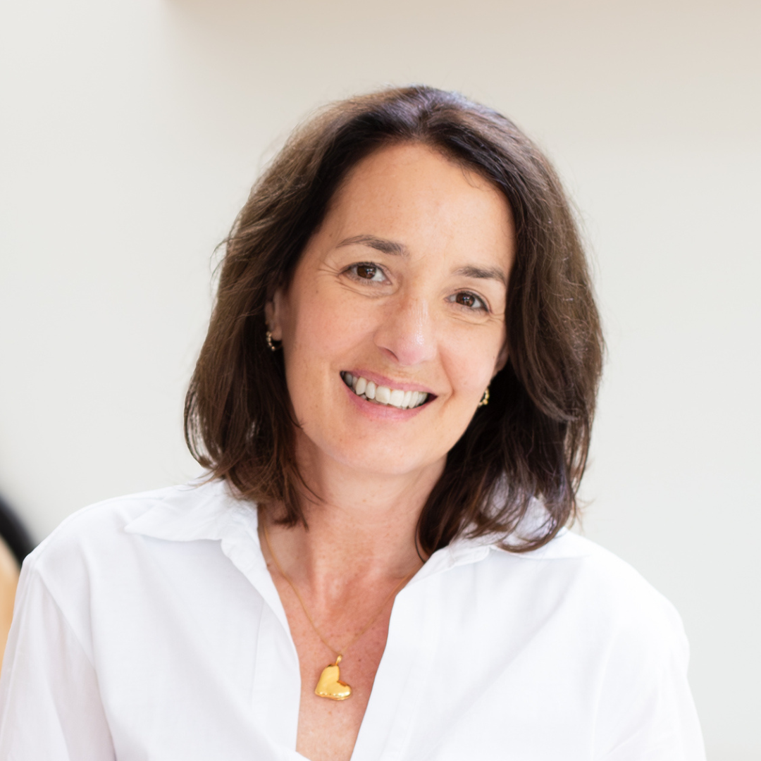 A headshot of a woman with brown hair in a bob cut smiling at the camera