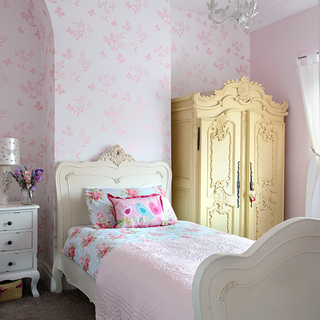 girls bedroom with cupboard and bedside table