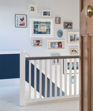 View of the stairway from a bedroom, with different size photo frames on the wall