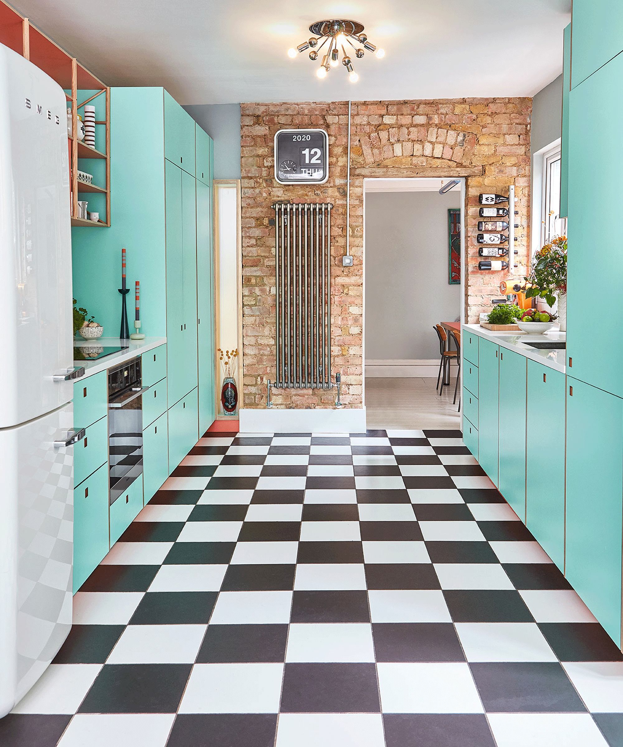 Turquoise galley kitchen with black and white flooring