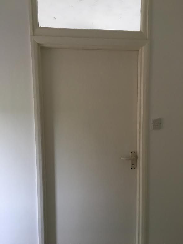 A cheap white modern door inside a listed building