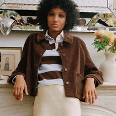 Woman in blazer, sweater, and jeans