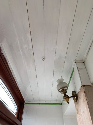 White porch wooden painted ceiling with wall light and pendant