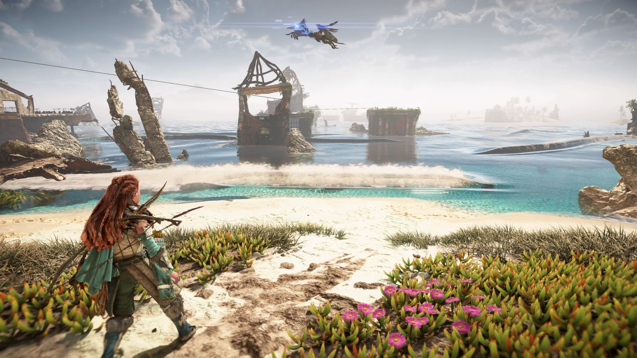 Aloy looks at the water by the beach in Horizon Forbidden West