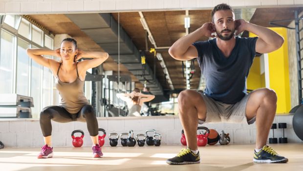 Man and woman perform unweighted squat