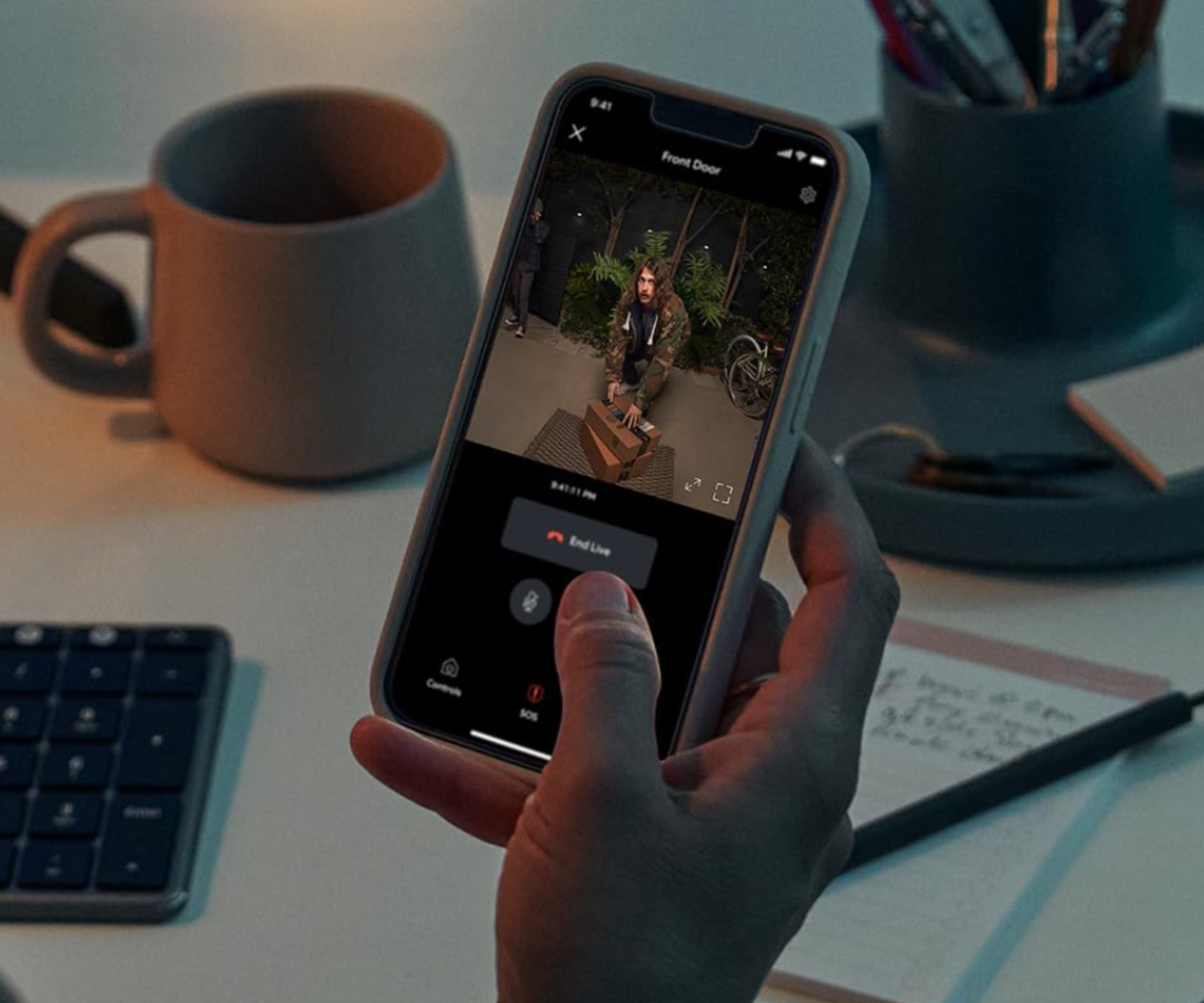 hand holding phone with Ring doorbell app showing man outside with clear night vision