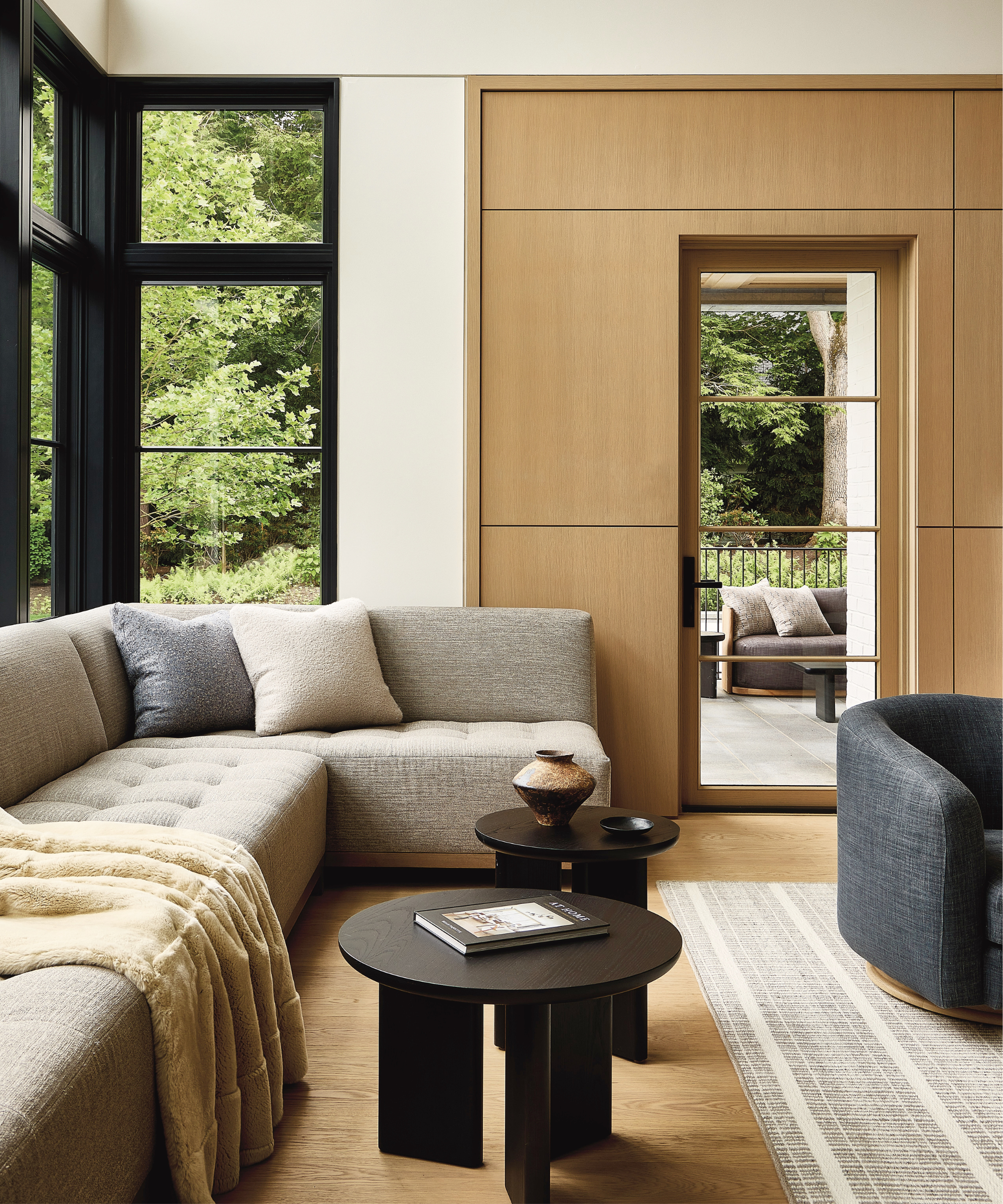 A view of a gray window seat with wood panels along the walls.