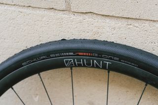 A black gravel tyre against a stone wall