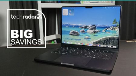 The MacBook Pro 14-inch (M5) during our tests in a home office, next to a TechRadar badge that reads 'Big Savings'