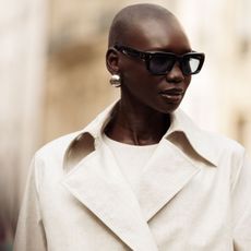 Best Silver Jewellery Woman wearing silver stud earrings, sunglasses and trench coat