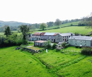 A three-acre plot with a number of barns and farm outbuildings made of stone