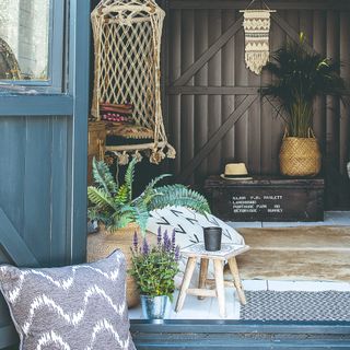 A garden office with break-out seating and cushions, decorated with potted plants