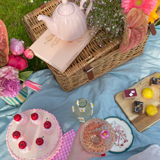 A beautiful picnic tablescape, with a fruit cake and pink teapot