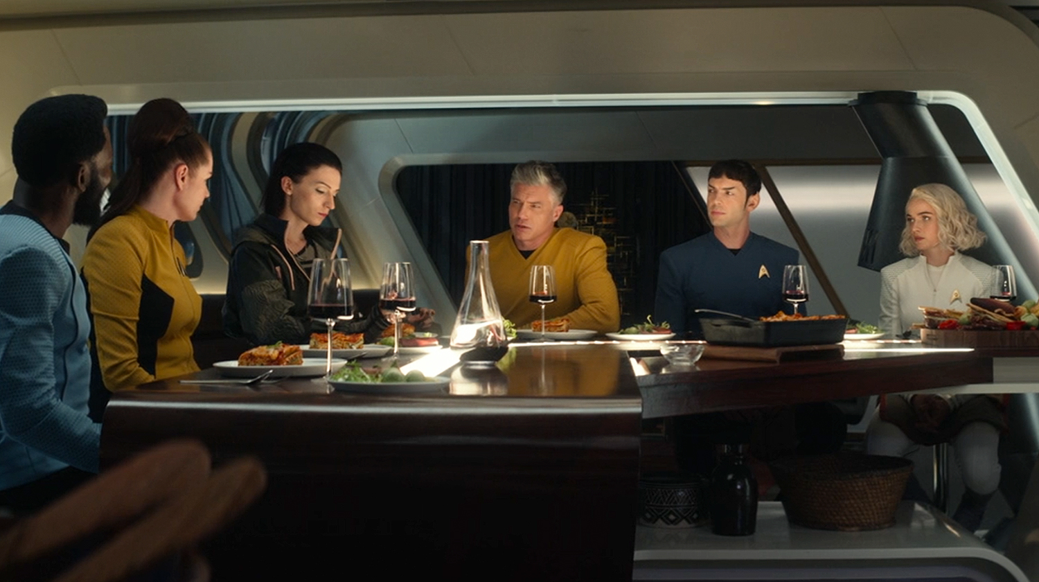 The starship Enterprise crew sits around the captain's table in episode 7 of Strange New Worlds.