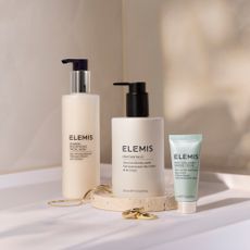 Three Elemis skincare bottles on beige background