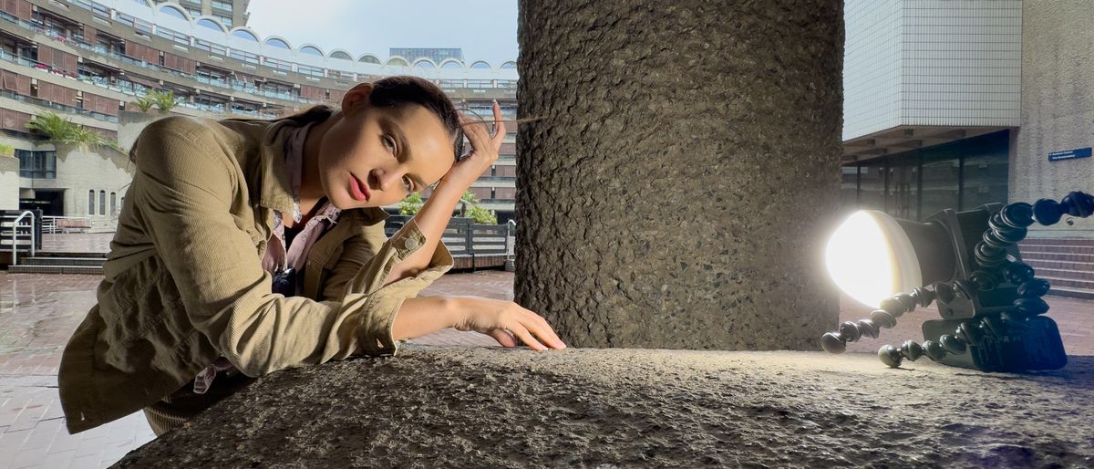 Woman leaning on a stone wall outside