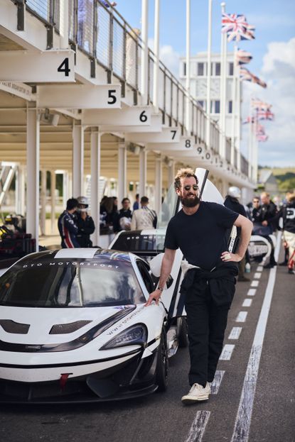James Fisher standing in front of a race car