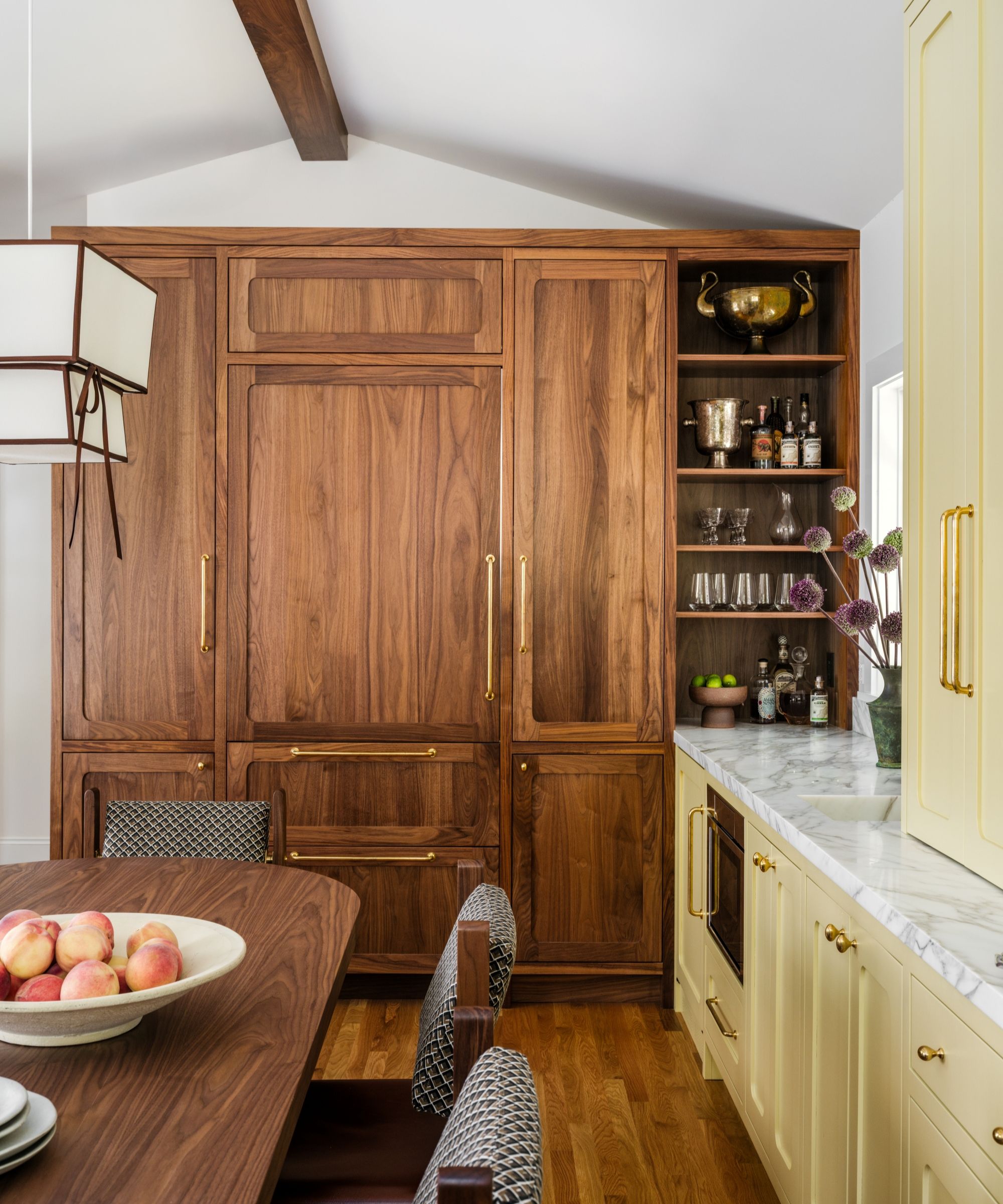 a yellow kitchen with a wall of wooden cabinets