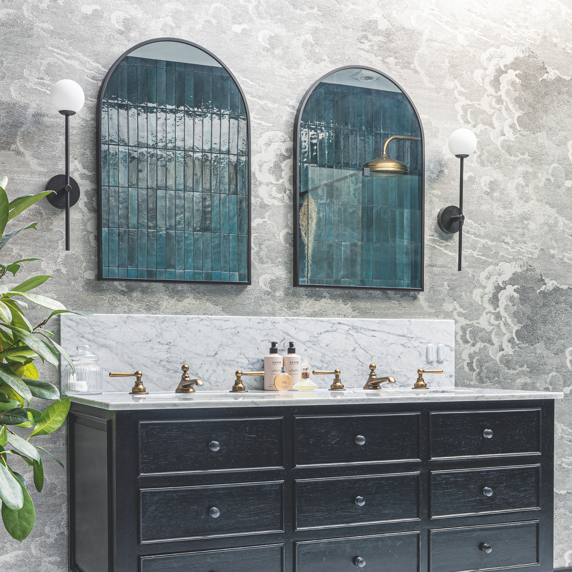 Marble sink area with blue tiles reflected within the mirror.