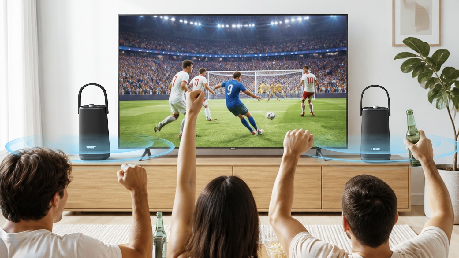 Two Tribit StormBox Max either side of television with people celebrating