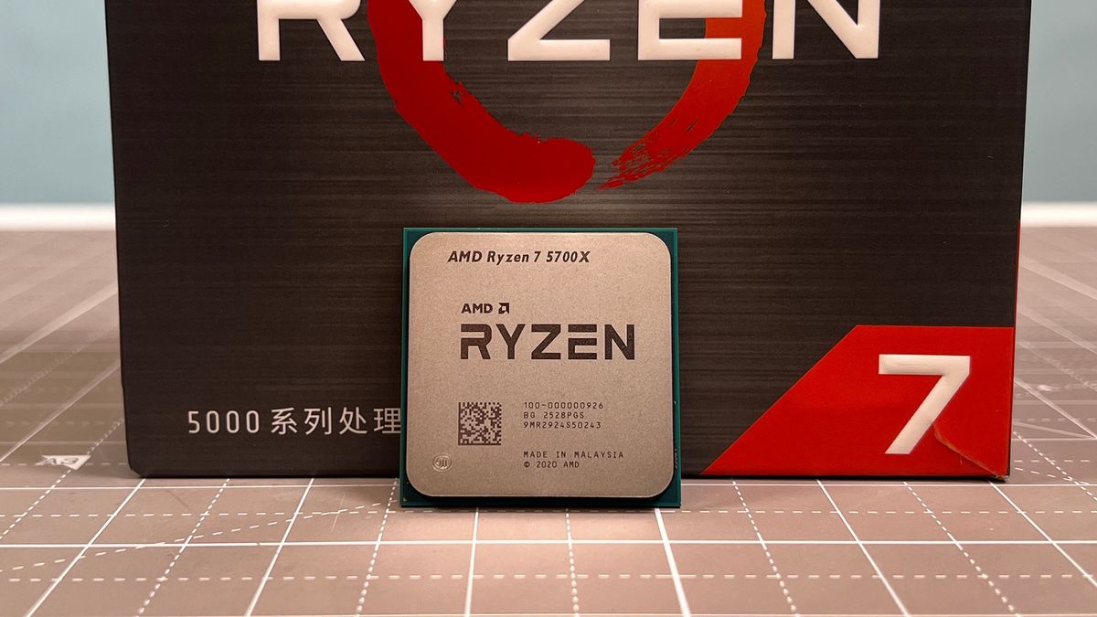 An AMD Ryzen 7 5700X standing upright next to its retail packaging