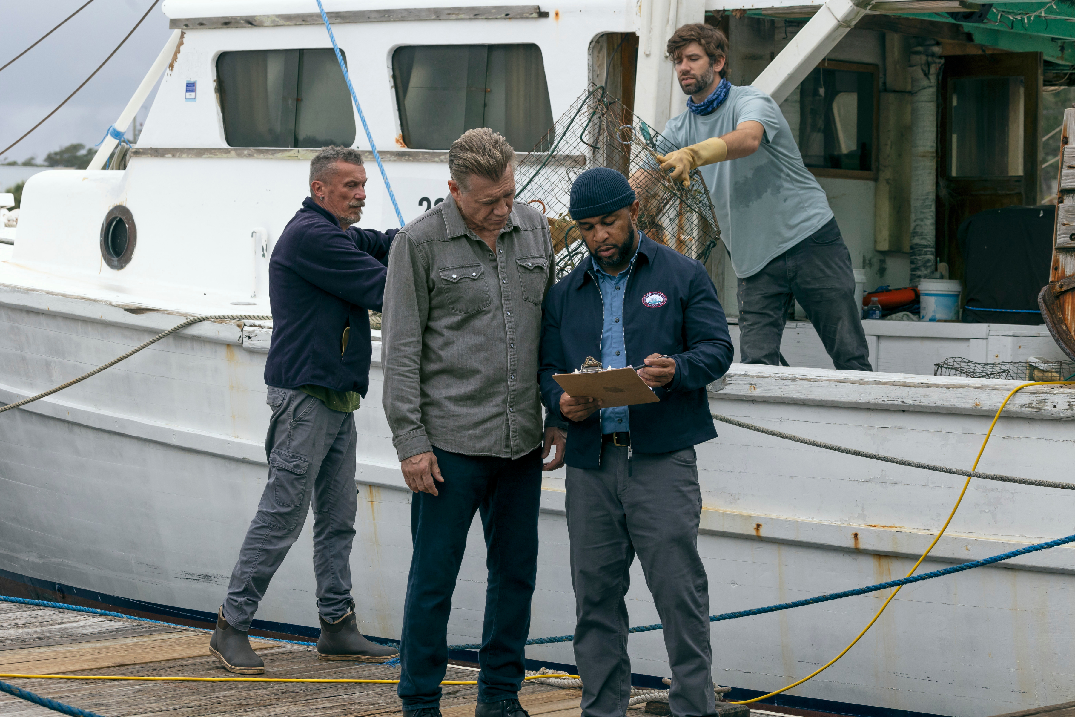 holt mccalley as harlan buckley talking to his staff on a fishing dock in the waterfront