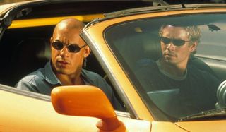 The Fast and the Furious Dom and Brian riding together in a yellow car