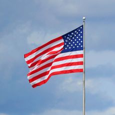The US flag set against a blue sky.