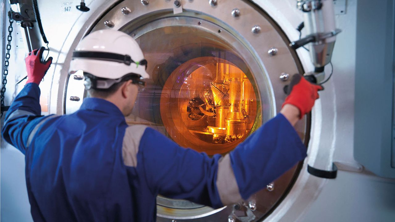 Engineer with fuel rod handling machine in nuclear power station