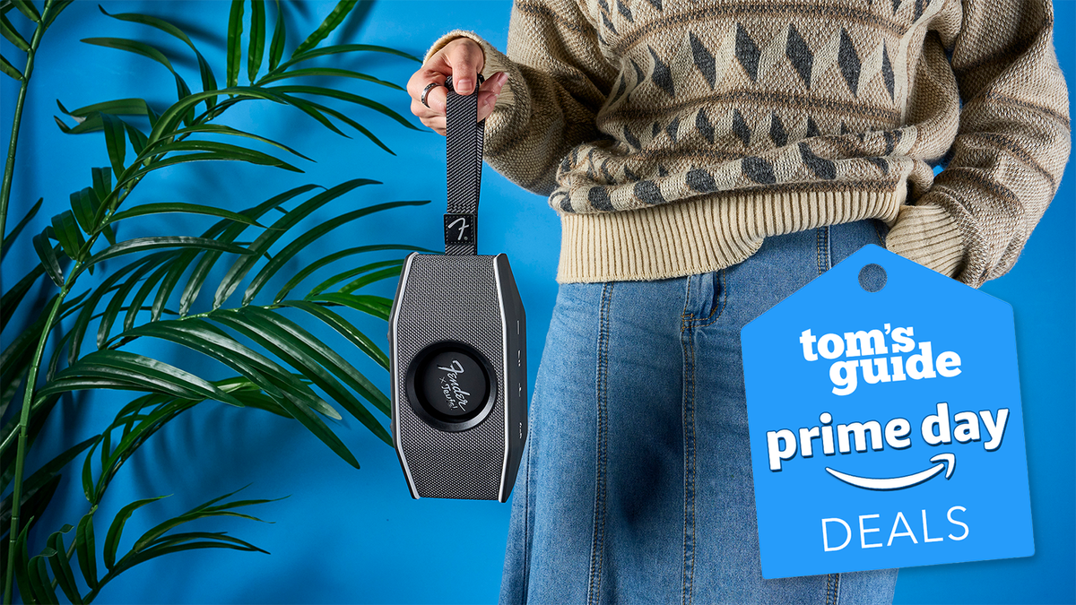 a gray and black retro speaker is held by a carry strap against a blue background