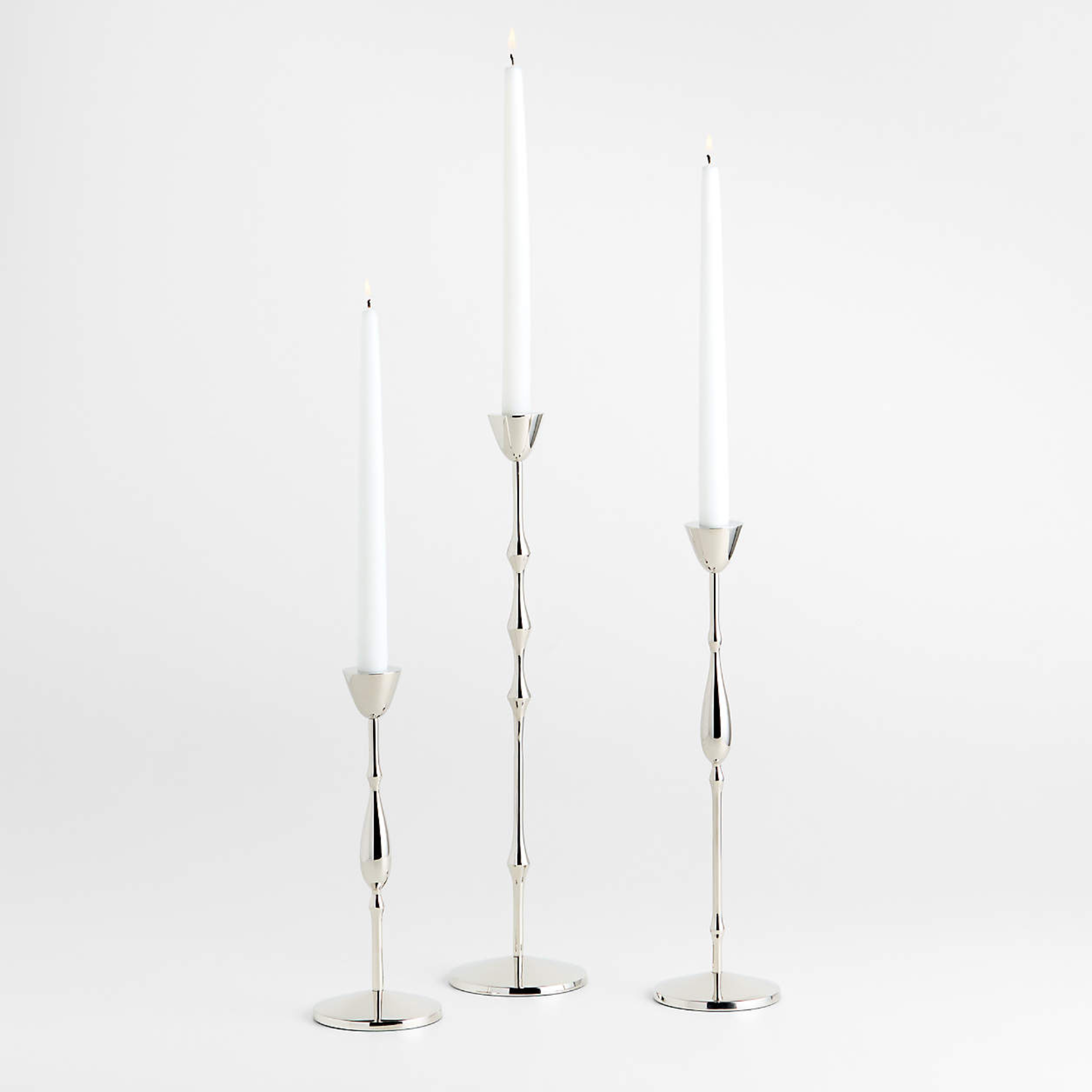 three silver candle holders in varying sizes