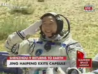 Chinese astronaut Jing Haipeng, commander of the Shenzhou 9 mission, salutes after exiting the space capsule following landing in Inner Mongolia autonomous mission on June 28, 2012.