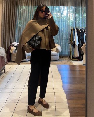 Woman wearing tan wrap jacket and jeweled flats.