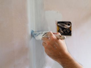 Painting new plaster with a mist coat