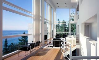 Interior view of house looking out of the large glass windows at the sea