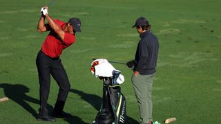 Tiger Woods is given a lesson by son Charlie before the final round of The Masters
