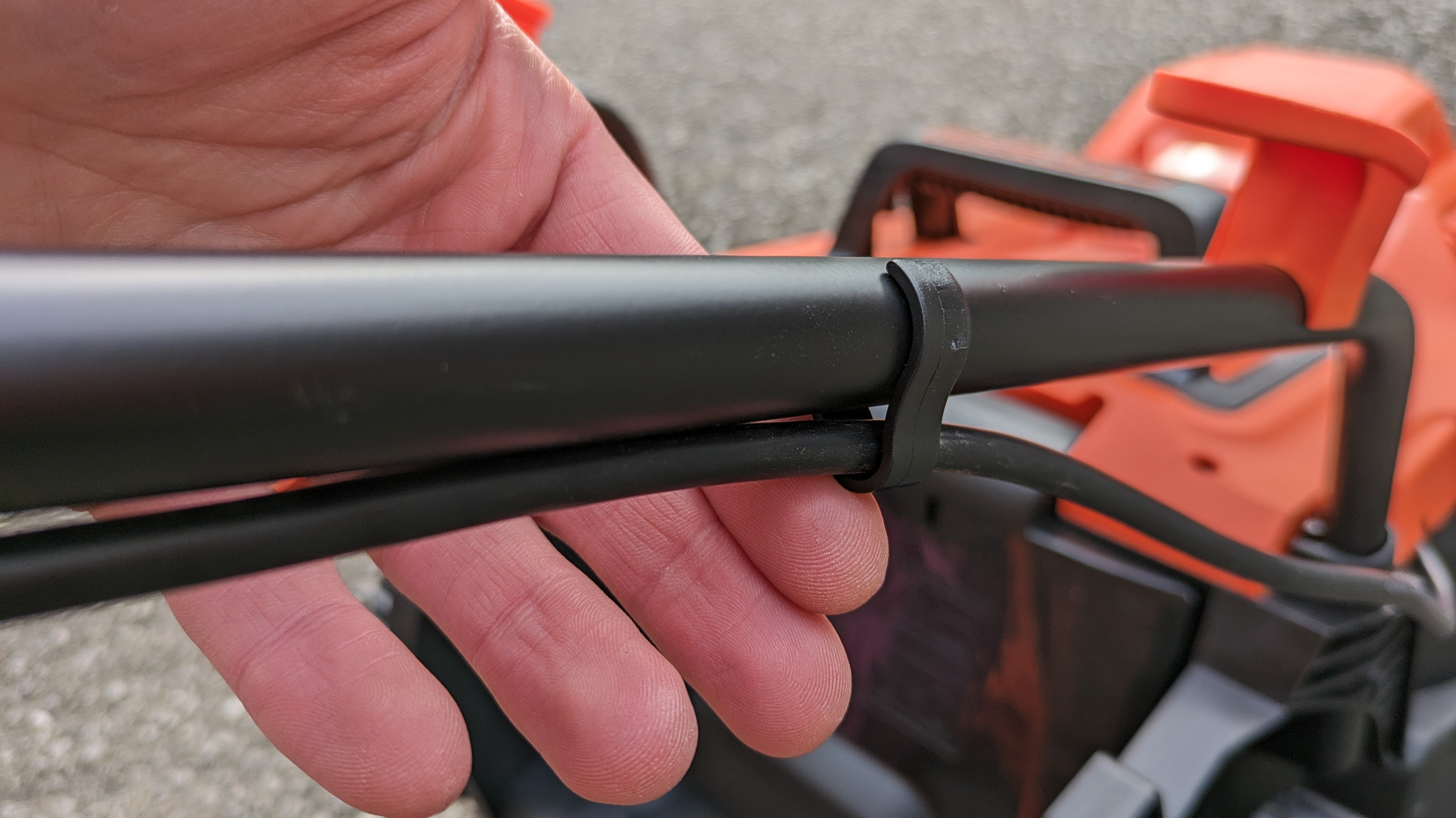 Attaching the cable management clips to the Black + Decker lawn mower.