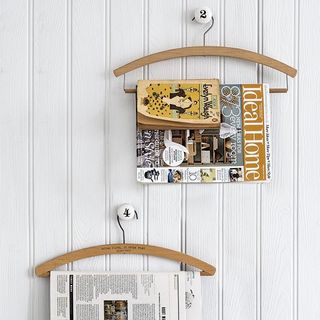 magazines and newspapers are hung on vintage wooden hangers