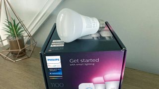 Philips Hue White and Color Ambiance A19 Bluetooth 75W Smart LED Bulb resting on box in writer's home