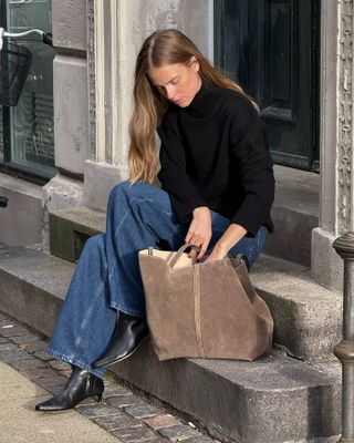 Winter outfit trends: @claradyrhauge carries a suede tote bag