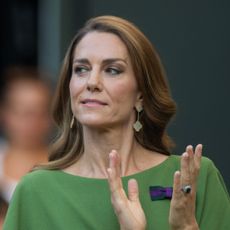 Princess Kate wears a green dress and has long brown hair with blonde highlights while applauding at Wimbledon 2026