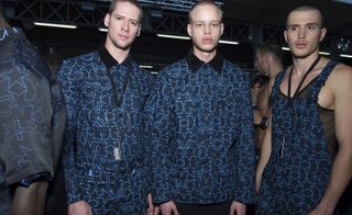 Three male models wearing clothing by Givenchy in blue shades.