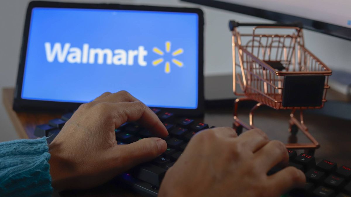 Man using gaming keyboard with tablet showing Walmart logo next to a 1/6 scale shopping cart