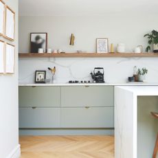 White kitchen with light green cabinets and wooden floor