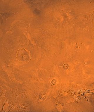 The Tharsis volcanic region of Mars, as seen by NASA's Viking mission. At left is the enormous Olympus Mons. The chain of volcanoes at lower right consists of, from bottom to top, Arsia, Pavonis and Ascraeus Mons.