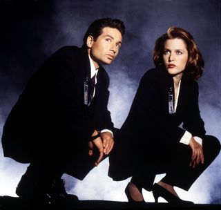 mulder and scully crouching down with smoke behind them in a still from The X Files