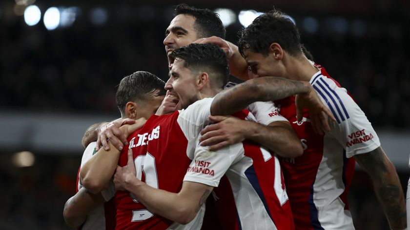 Arsenal players huddle and hug in celebration of a goal in a Carabao Cup game