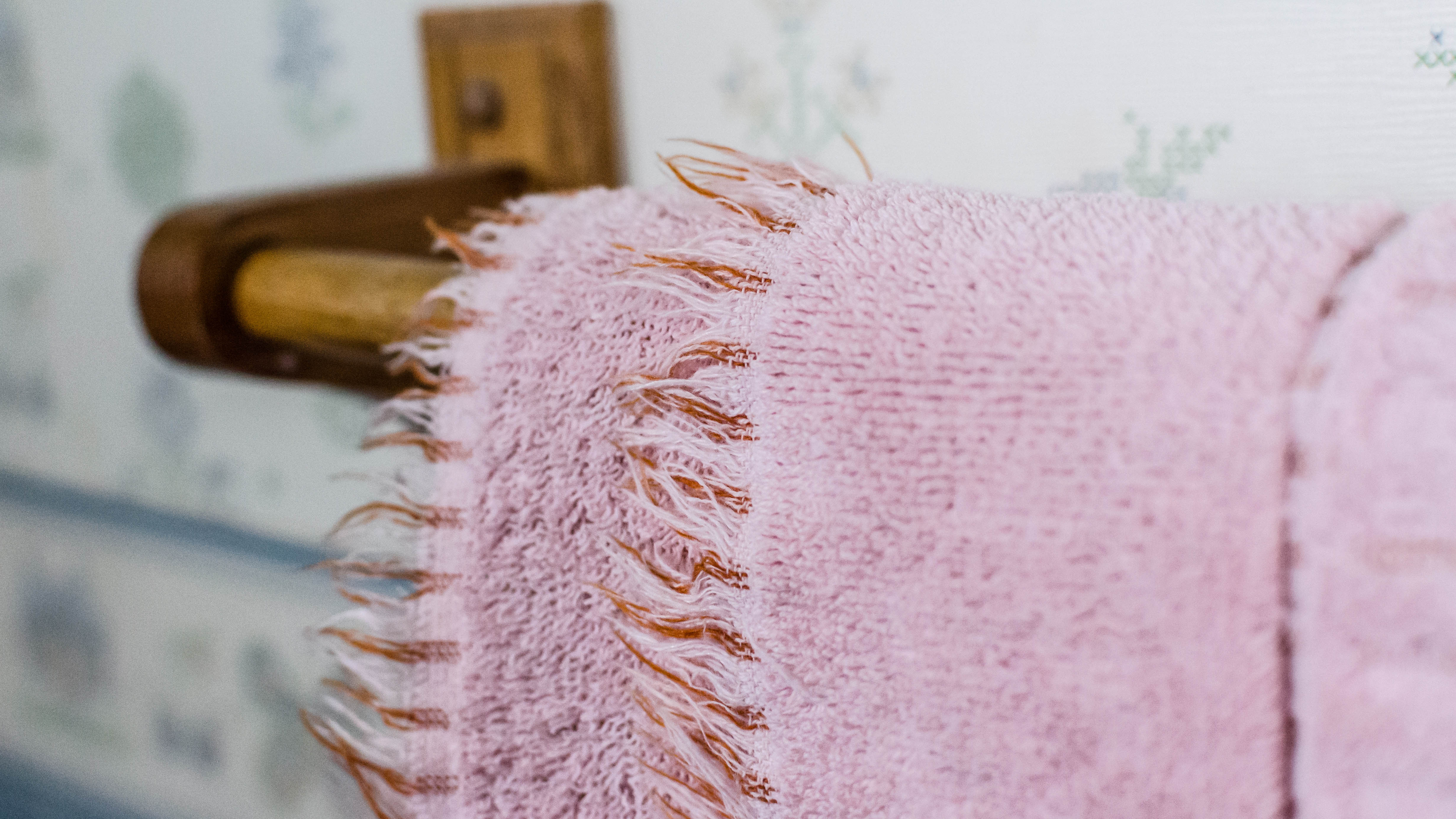 Frayed pink towel hanging on a rail